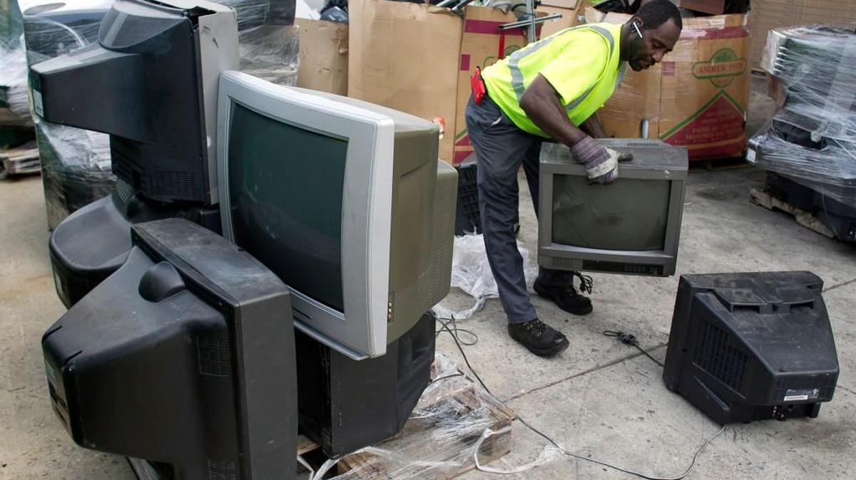 An employee moves discarded television sets to a pallet at the North Wake Multi-Material Recycling Center so they can be loaded into a truck in July 2015 on Deponie Drive in Raleigh.