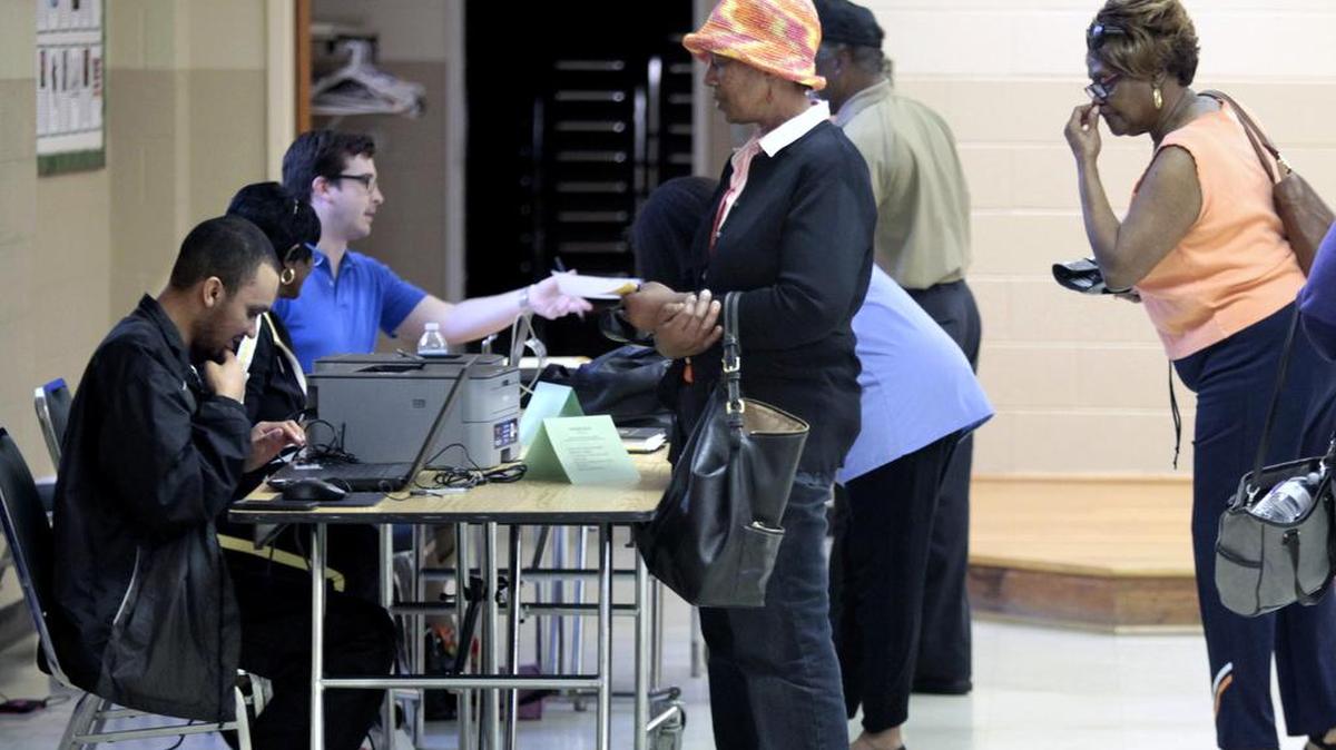 White Rock Baptist Church precinct workers verify the ID and hand out ballots to early afternoon voters at the south Durham voting precinct on Fayetteville Road, Durham, NC Tuesday, March 15, 2016.