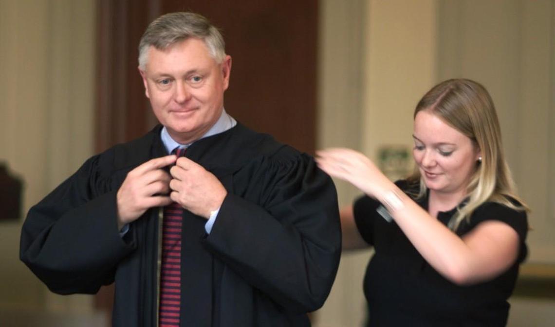 Sarah McCullough (right), helps her father Douglas McCullough (left) into his robes after McCullough is sworn in as Associate Judge of the North Carolina Court of Appeals in 2001.