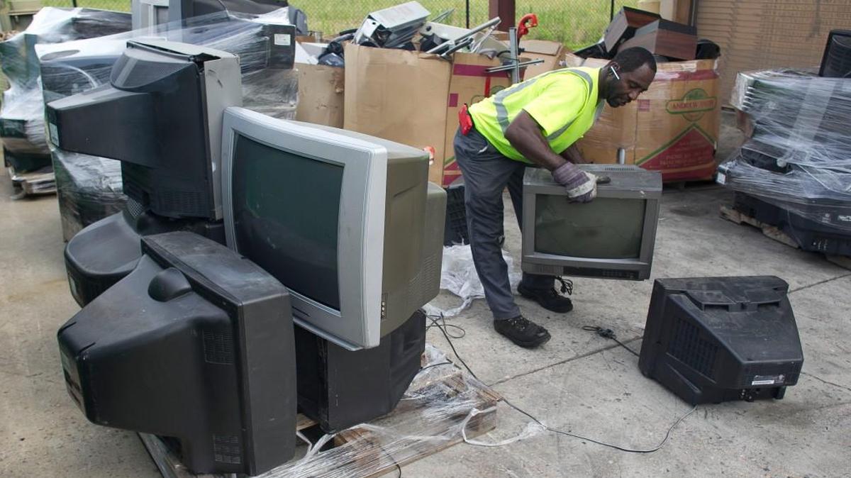 North Wake Multi-Material Recycling Center employee Charles Snead moves discarded television sets to a pallet so they can be loaded into a truck in July 2015. A provision in this year’s deregulation bill would lift the ban on discarding computers, televisions and other electronics in landfills.