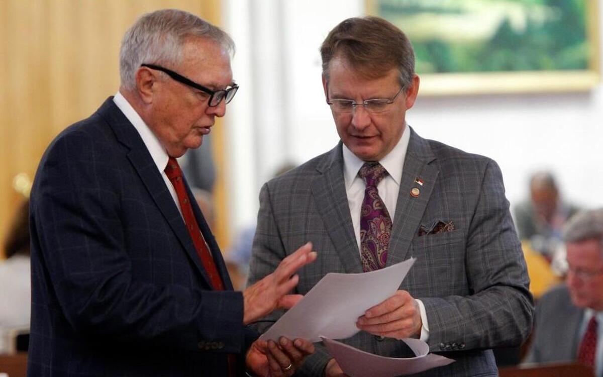 Rep. Leo Daughtry (R), left, and Rep. Mike Hager (R) confer on the floor of the N.C. House at the Legislative Building in Raleigh, NC on May 15, 2014. Hager, now the House majority leader, is calling for a criminal investigation of a political committee.