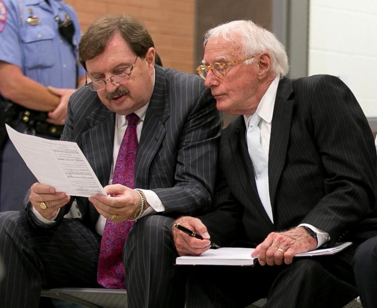 Sen. Fletcher Hartsell, left, reads his indictment with attorney Wade Smith as they wait to appear before a magistrate at the Wake County Detention Center on Tuesday, June 28, 2016 in Raleigh, N.C.