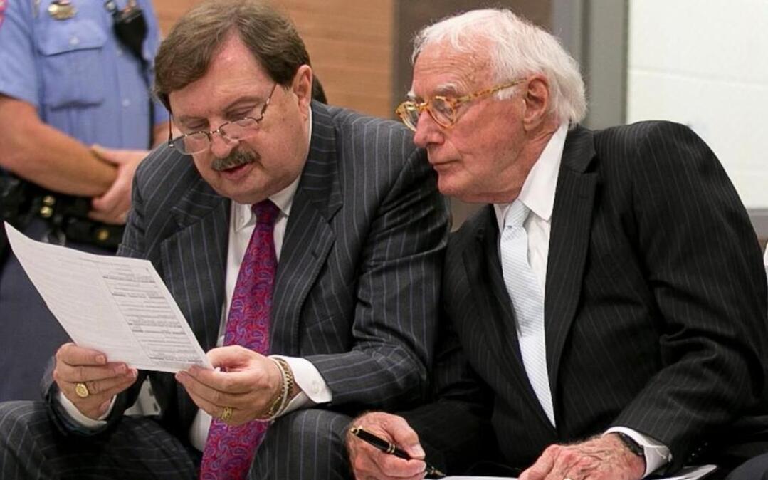Sen. Fletcher Hartsell, left, reads his indictment with attorney Wade Smith as they wait to appear before a magistrate at the Wake County Detention Center on Tuesday, June 28, 2016 in Raleigh, N.C.