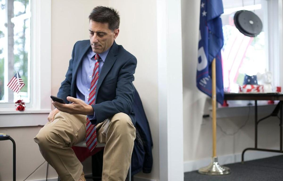 Dallas Woodhouse, the executive director of the North Carolina Republican Party, checks his phone as he prepares for a press conference on Monday, October 16, 2017, at the Orange County Republican headquarters in Hillsborough, N.C.