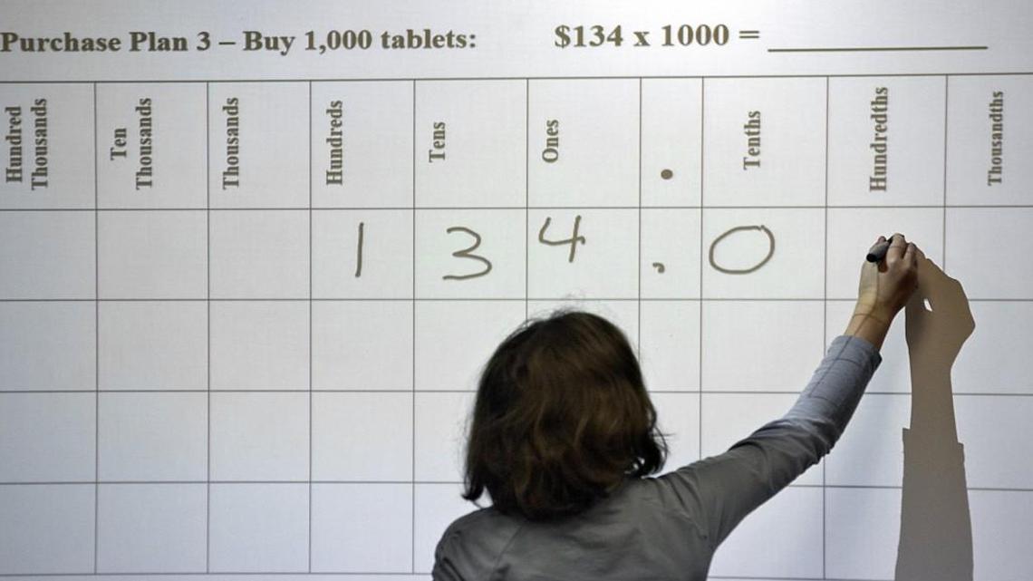 Students, like Miriam Cooper, working a problem at the Smartboard, participate in math problems in Dana Snapp's class at Fuquay-Varina Elementary School. Students there have been using Common Core Math for the past four years. School administrators say it is working for both the students and teachers, while some parents are looking to get rid of it. Rene Herrick, teacher leadership specialist in mathematics at the school, not seen, says the system is important to keep in place.