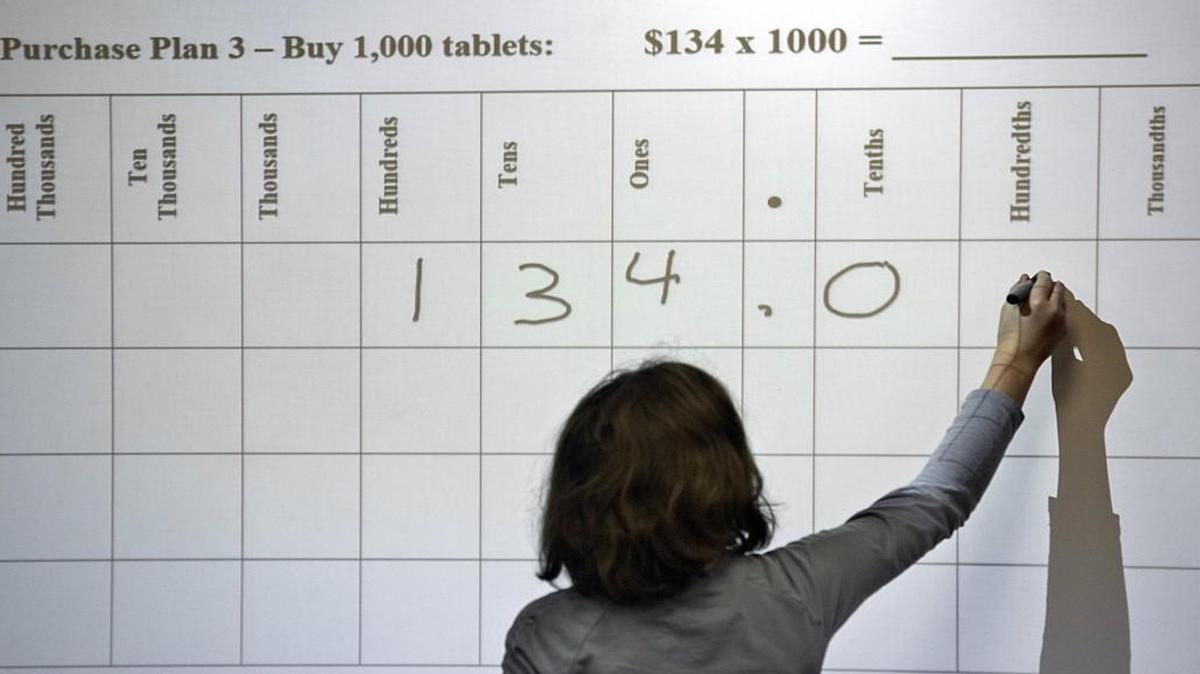 Students, like Miriam Cooper, working a problem at the Smartboard, participate in math problems in Dana Snapp's class at Fuquay-Varina Elementary School. Students there have been using Common Core Math for the past four years. School administrators say it is working for both the students and teachers, while some parents are looking to get rid of it. Rene Herrick, teacher leadership specialist in mathematics at the school, not seen, says the system is important to keep in place.
