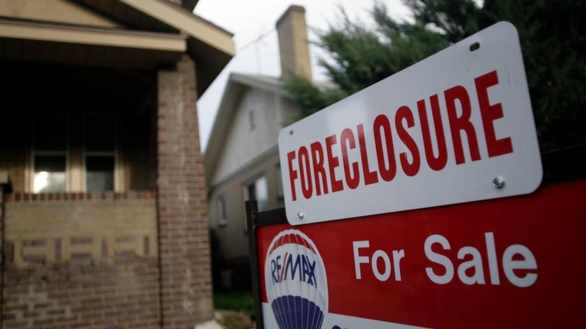 A foreclosure sign tops a sale sign outside an existing home on the market in Denver in this Aug. 29, 2007 file photo.
