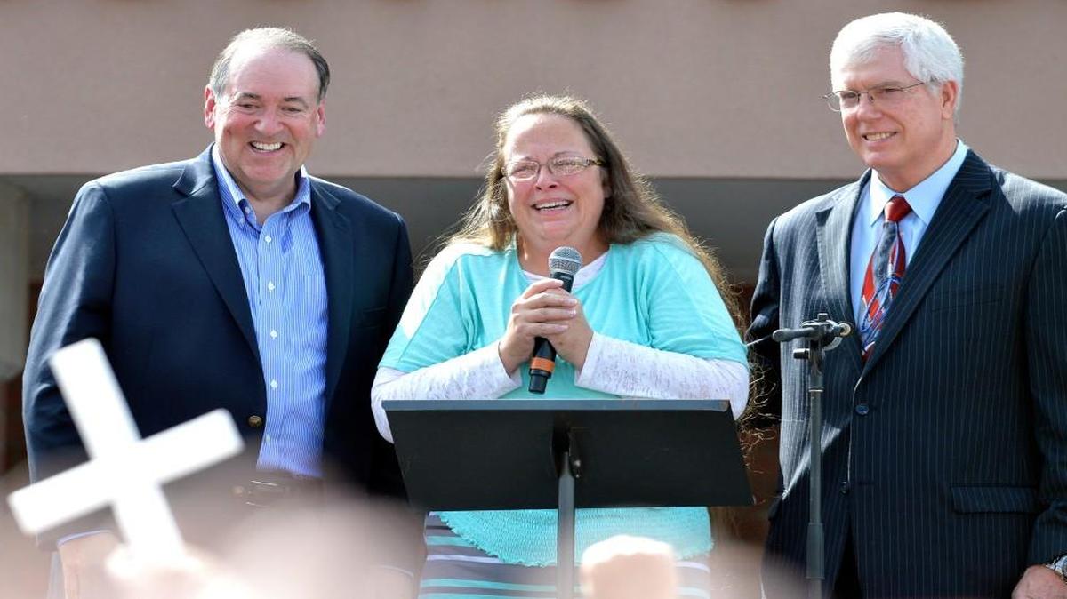 Rowan County Clerk Kim Davis, center with Republican presidential candidate Mike Huckabee, left, and attorney Mat Staver, right, founder of the Liberty Counsel, the Christian law firm representing Davis, at her side, greets the crowd after being released from the Carter County Detention Center, Tuesday, Sept. 8, 2015, in Grayson, Ky.