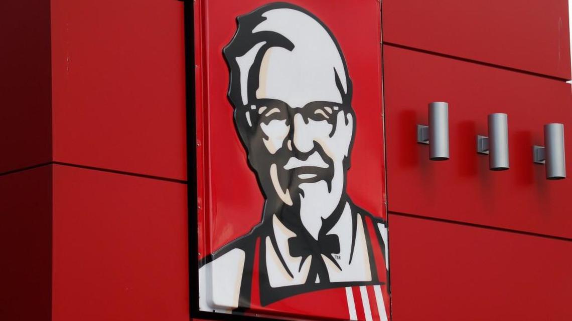 FILE - In this Tuesday, Oct. 9, 2012, file photo, a close-up of a sign with a picture of Colonel Sanders is shown on the wall of a combination Kentucky Fried Chicken, Taco Bell in Doral, Fla.