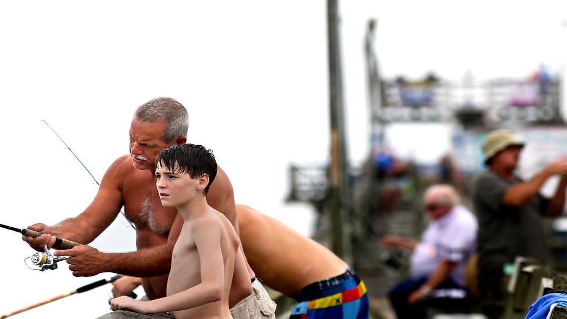 Mitch Parker, of Emerald Isle, helps his grandson Darren Parker, 14, of Wilson, cast his line on the Bogue Inlet Fishing Pier in Emerald Isle, N.C. on Monday, July 13, 2015.