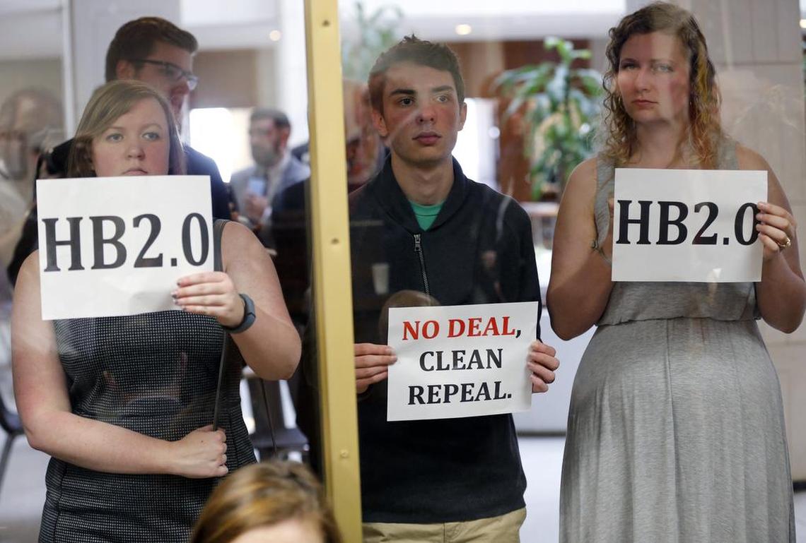 Opponents of a proposed replacement for House Bill 2 hold protest signs outside a room where supporters of the proposal held a press conference at the N.C. General Assembly in Raleigh, NC on Feb. 28, 2017.