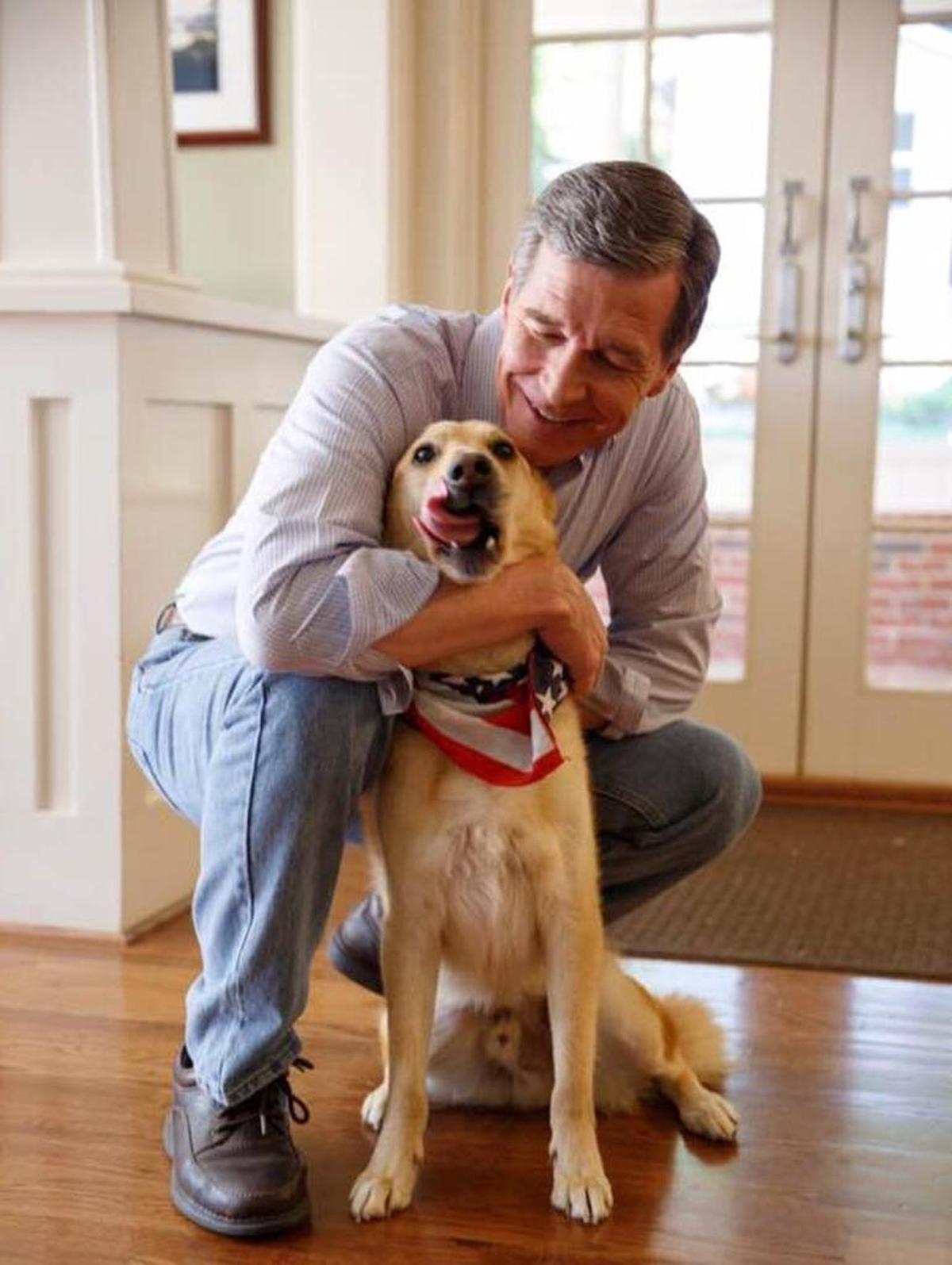 Gov. Roy Cooper with his “grand-dog” Ben, who enjoys “sitting on his loved one’s feet and licking himself,” according to a Facebook page created for the governor’s pets.