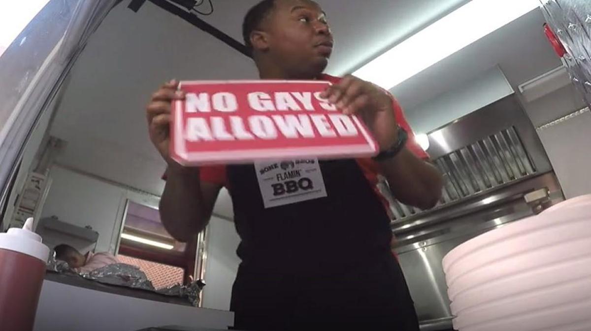 Daily Show correspondent Roy Wood Jr. posts a “no gays allowed” sign at a fake barbecue food truck while filming outside Trophy Brewing in Raleigh.