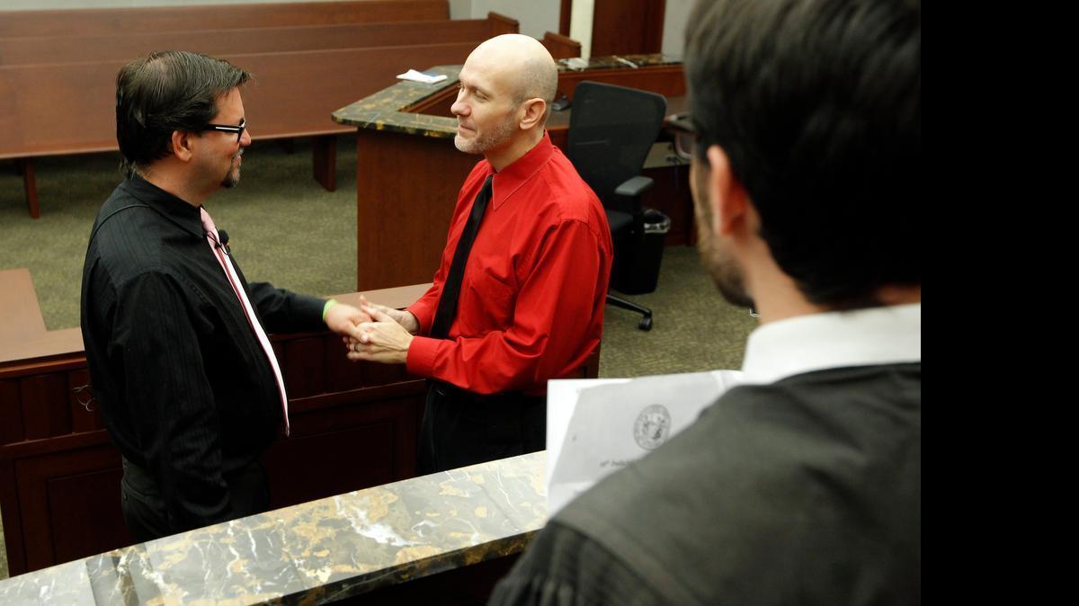 
Same sex couple Craig Johnson, left, and Shawn Long, center, are married by Magistrate Jacob Davis, right, in downtown Raleigh in October. Gov. McCrory says he will veto a bill to allow magistrates to opt out of performing marriage if they have a religious objection.
