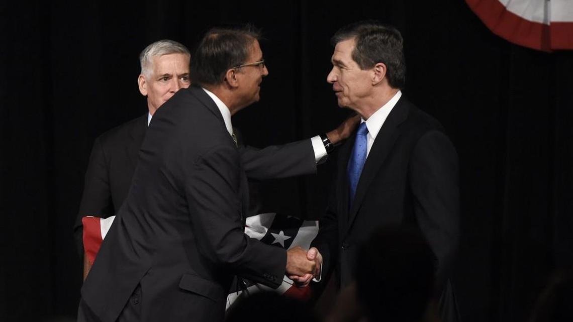 Gov. Pat McCrory (left) and Attorney General Roy Cooper greet each other after a debate in June. Now, with North Carolina’s governor’s race still undecided after two weeks, political observers are taking another look at the disputed 2004 election for state superintendent of public instruction.
