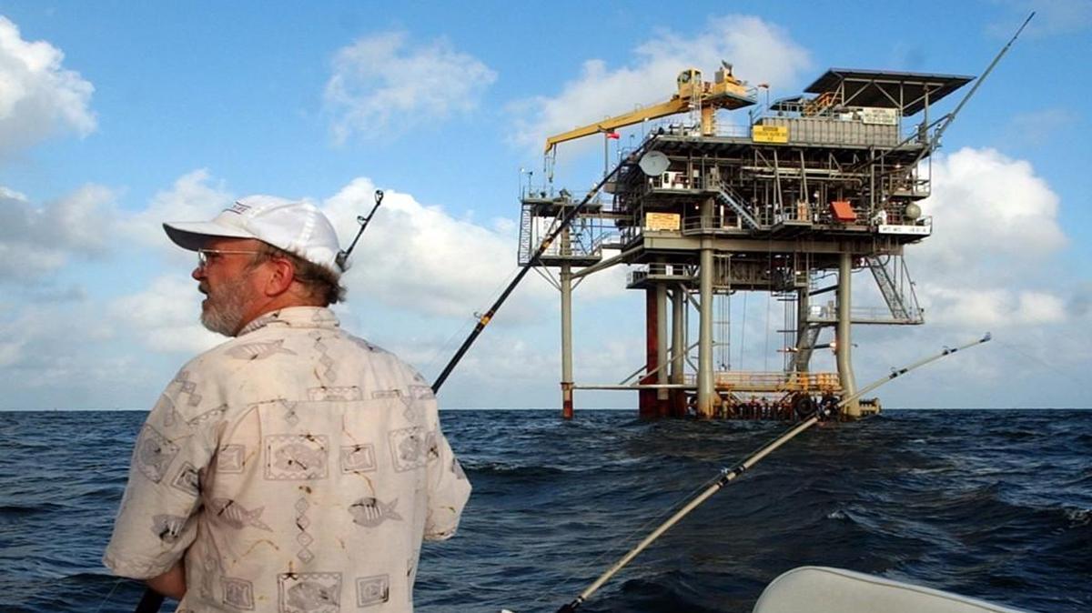 Angler Andy Hails, of Montgomery, Ala., checks the fishing lines on his boat as he trolls the Gulf of Mexico near a natural gas well off the Alabama coast near Gulf Shores, Ala. President Donald Trump on Friday, April 28, 2017, signed an executive order to consider new offshore drilling around the country.