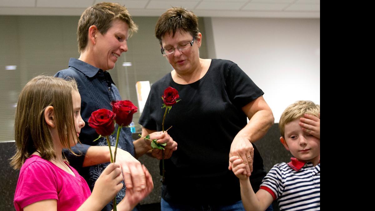 
With their children, Phinnlei, 6, and Oliver Scott, 4, Christian Scott, left, of Apex, gets married to her partner Robyn Ross, right, around 9:15pm at the Wake County Justice Center on Friday, October 10, 2014. They were the second-to-last couple to tie the knot on the first day that same-sex marriages could take place in North Carolina.
