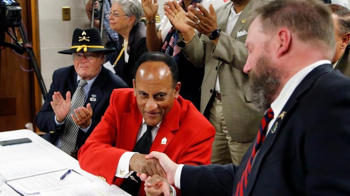 Larry Hall, center, is congratulated by supporter Gordon Jeans, right, after he was confirmed as Secretary for Military and Veterans Affairs by a Senate committee at the N.C. Legislative Building on March 2, 2017.