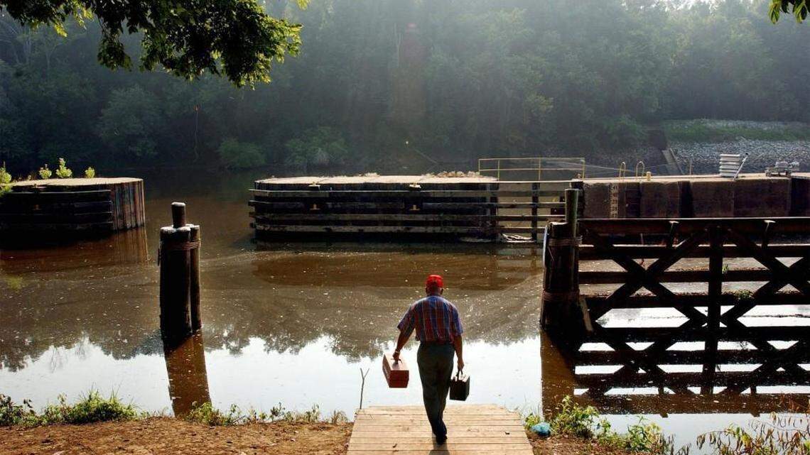 Billy Locklear, from Robeson County, brings his tackle box to the shores of the Cape Fear River at the William O. Huske Lock and Dam off NC 87 in Bladen County on July 22, 2004.