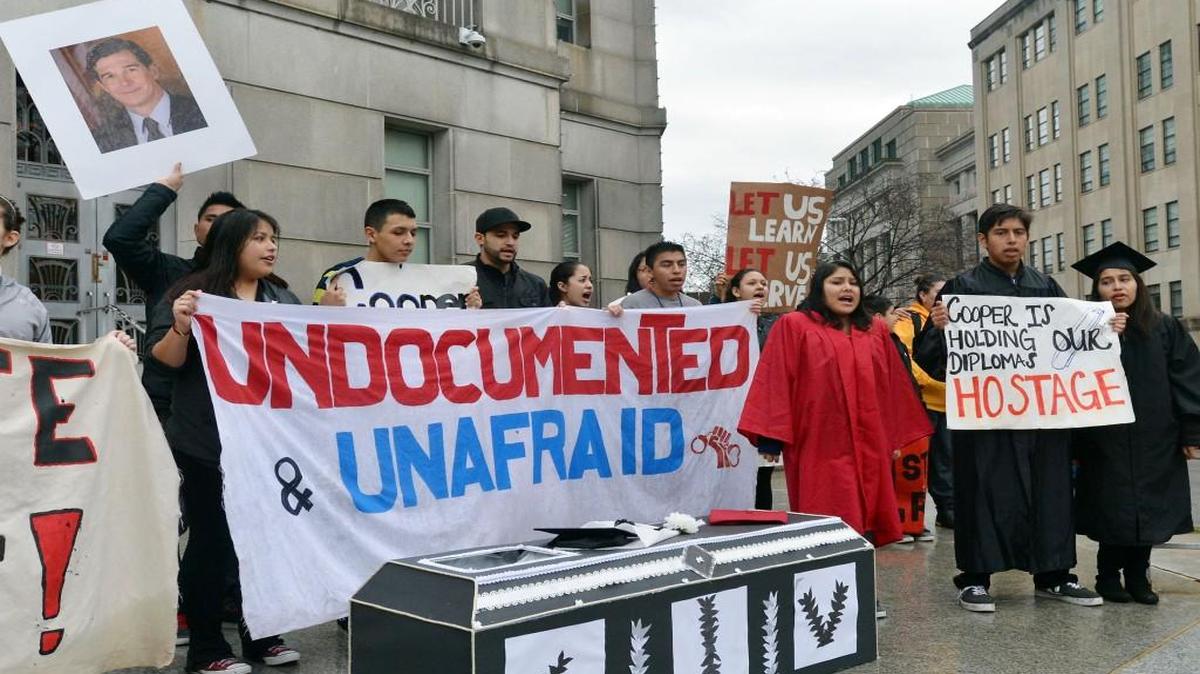 
Immigration activists chant behind a cardboard coffin on the front steps of the Attorney General's office at in 2014. Legislation approved in the state House would ban local governments from refusing to enforce immigration laws.

