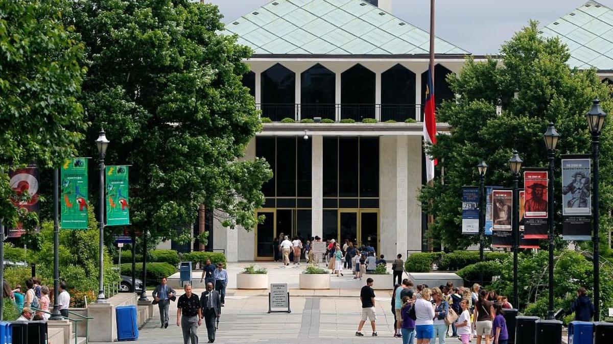 People mill about on Bicentennial Plaza with the N.C. Legislative Building in the background on May 15, 2014.