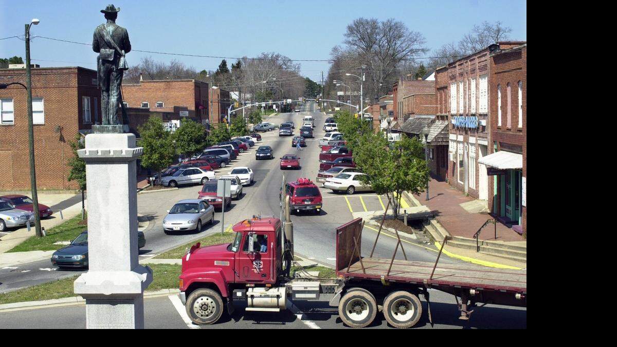 
A statue of a Confederate solder looks north on Hillsboro Street from the traffic circle of downtown Pittsboro, NC. 
