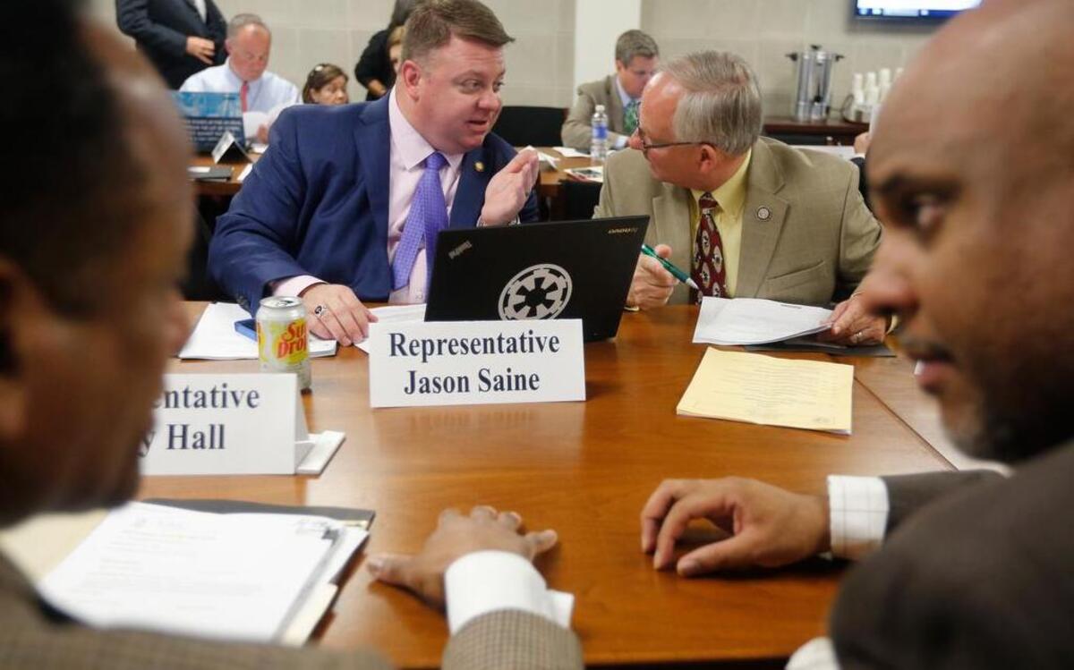 Rep. Jason Saine, back left, and Rep. James Boles, back right, along with Rep. Larry Hall, front left, and Rep. Edward Hanes, Jr., front right, talk before the start of the House Rules, Calendar and Operations committee meeting in the Legislative Building in Raleigh, N.C., Wednesday, April 29, 2015. 
