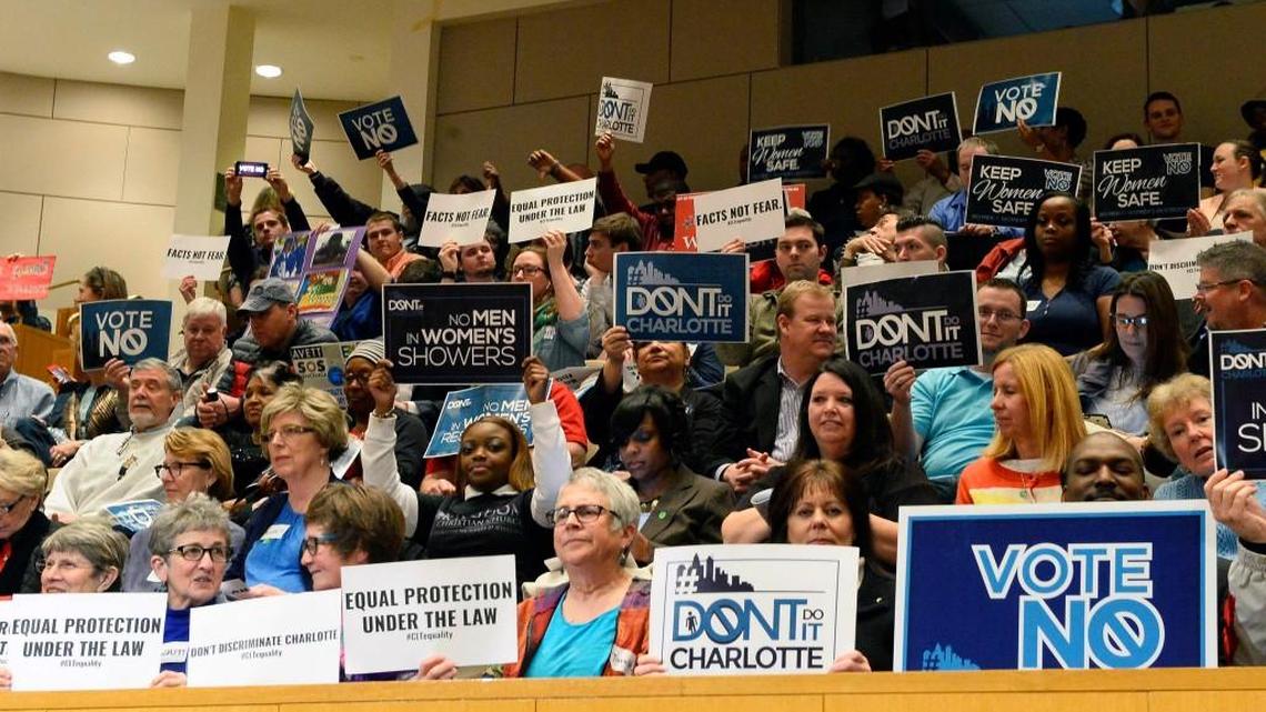 Members of the audience on both sides of the issue hold up signs before the start of Monday's City Council meeting's vote on the nondiscrimination ordinance, Feb. 22, 2016.