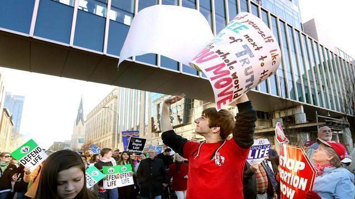 
Daniel White, 20, from Raleigh, waves to visitors of the North Carolina Museum of Natural Sciences as White and more than 1,500 community members march down South Salisbury Street in support of pro-life during the March for Life in downtown Raleigh in this Saturday, Jan. 17, 2015, file photo.
