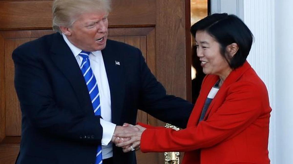 Then-President-elect Donald Trump shakes hands with Michelle Rhee, a former chancellor of Washington, D.C., schools, and her husband, former NBA basketball player Kevin Johnson, left, in November.