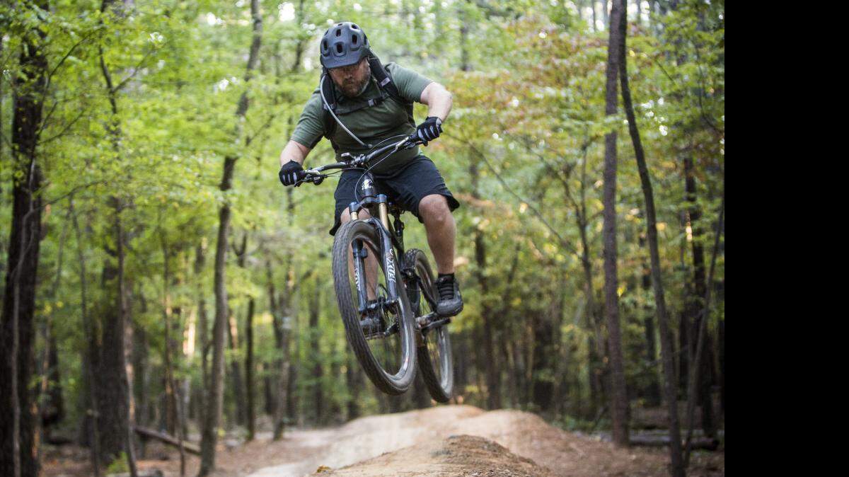 
Shawn Troy of Cleveland rides the popular mountain bike trails on RDU Airport Authority'e FATS tract leased by the Lake Crabtree County Park Wednesday, October 8, 2014. Wake County has leased the land from the airport authority that gives visitors to Lake Crabtree County Park extra acreage on which to hike, geocache and mountain bike. But last year, the airport authority wouldn't renew the lease, saying it wanted to consider development options for the property. 
