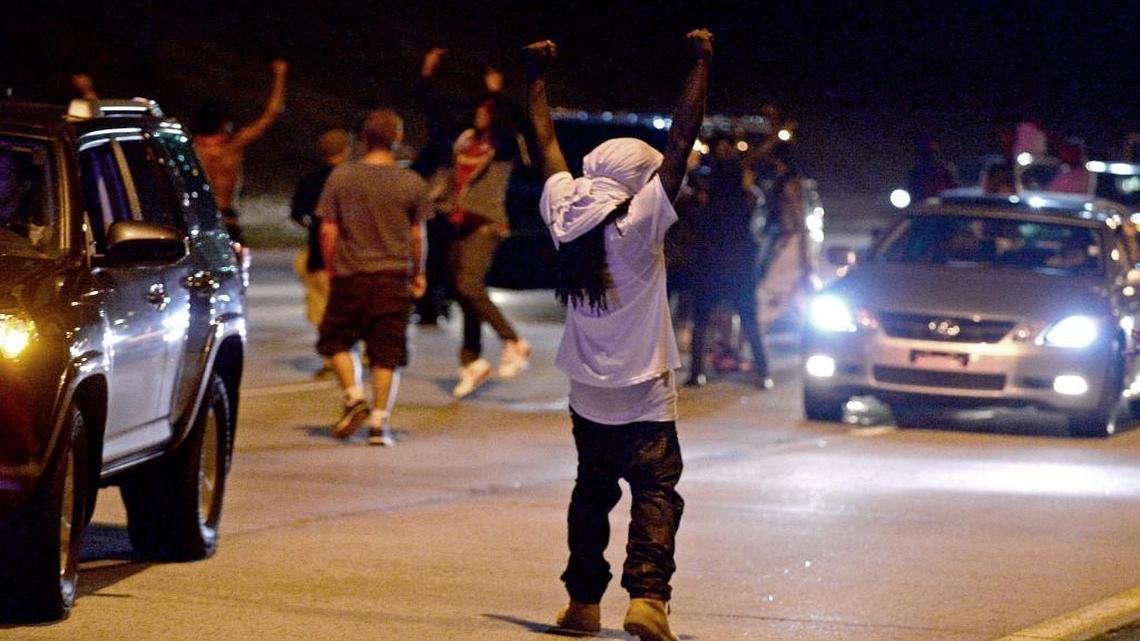 A protester raises his fists in the air after he and other protesters were able to block Interstate 277 in Charlotte, NC on Thursday, September 22, 2016. An N.C. House bill would create tougher penalties for protesters who block traffic.