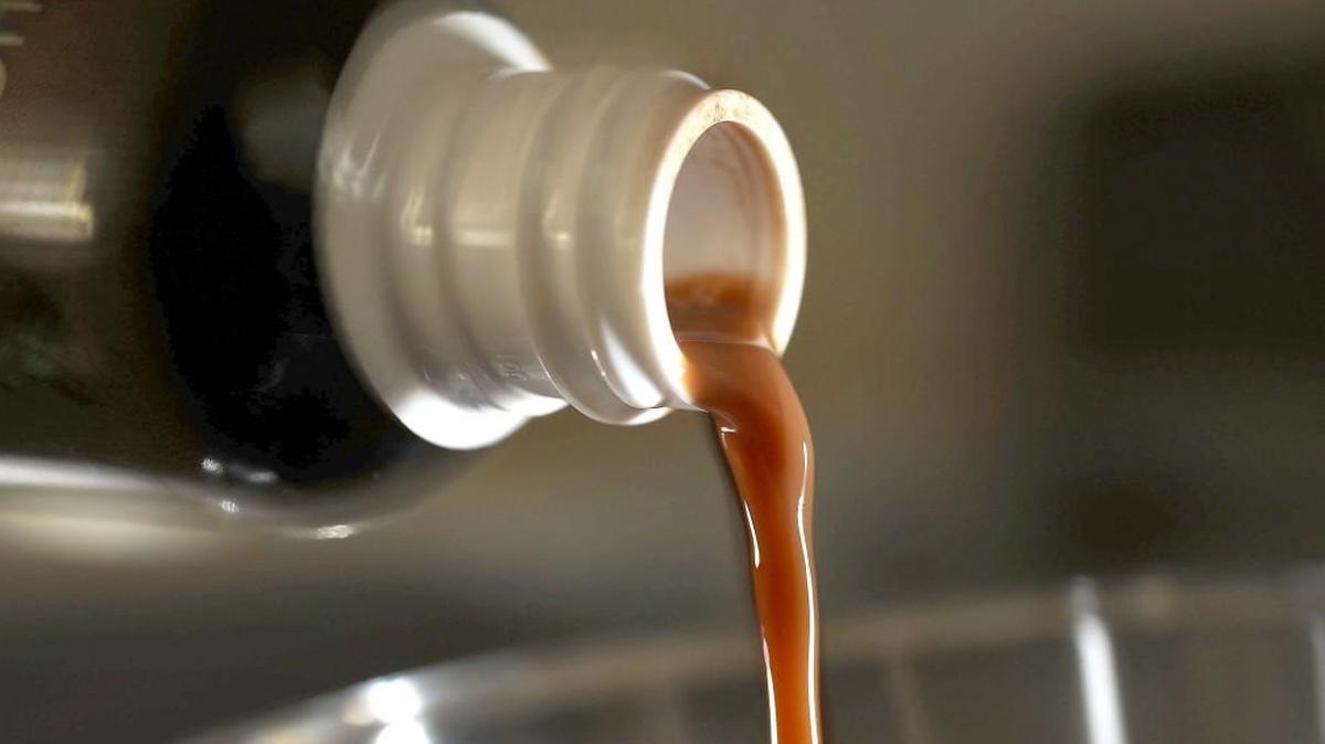 A liquid form of the herbal supplement kratom is poured from a bottle in this photo illustration.