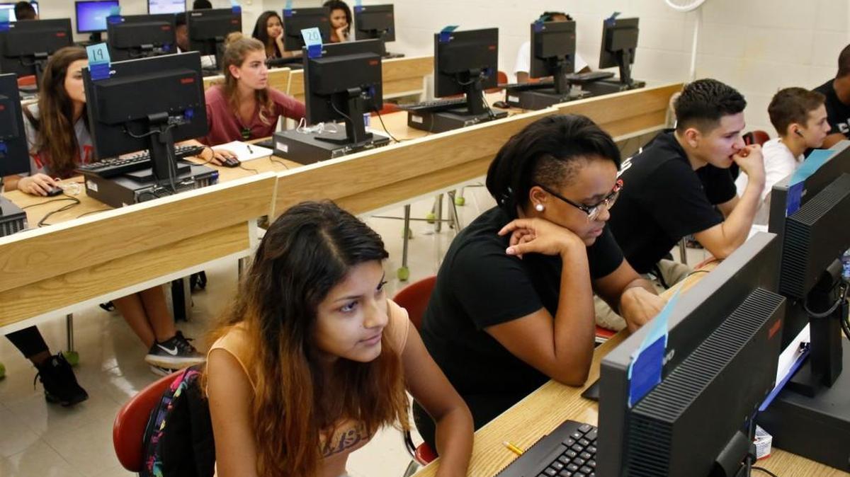 Ruby Torres, left, and Cierra Vick focus on online lessons in September at Sanderson High School in Raleigh. Two online schools have expanded the number of charter schools in the state.