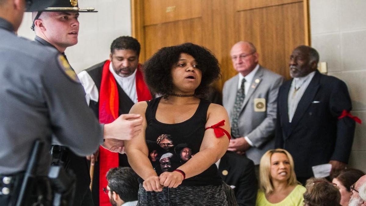 Rebekah Barber, the daughter of Rev. William Barber II, holds her wrists out while being arrested Tuesday, May 30, 2017 at the NC Legislative building. Thirty-two people were arrested for second-degree trespassing according to General Assembly police chief Martin Brock.