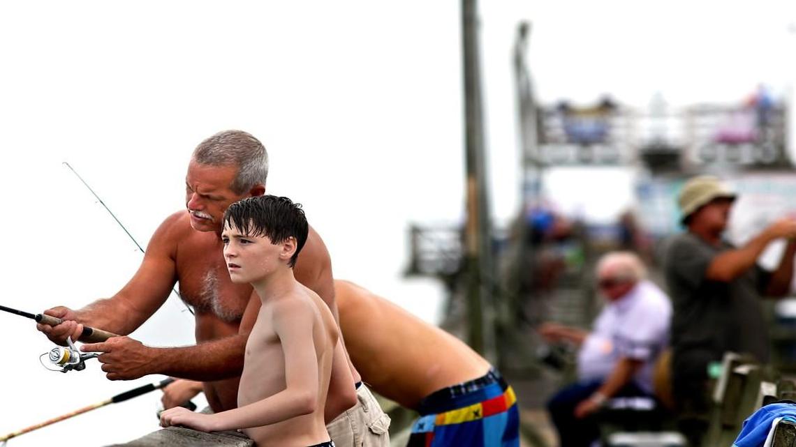 Mitch Parker, of Emerald Isle, helps his grandson Darren Parker, 14, of Wilson, cast his line on the Bogue Inlet Fishing Pier in Emerald Isle, N.C. on Monday, July 13, 2015.