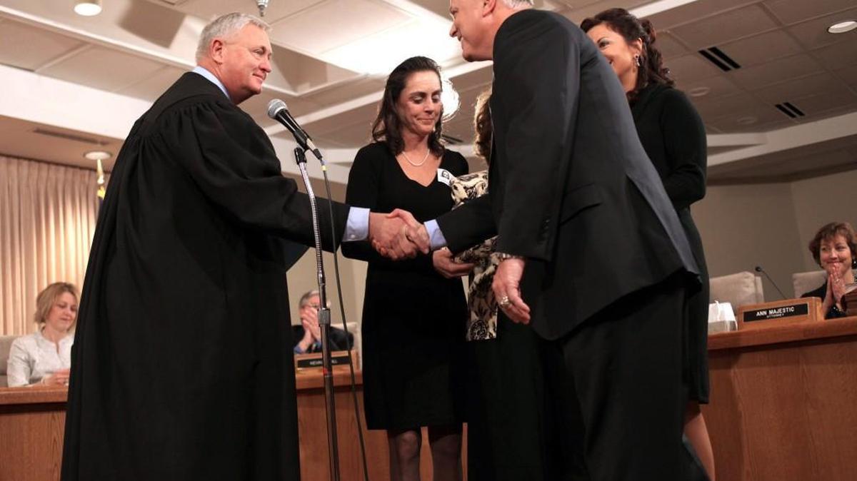 Former NC Appeals Court Judge Doug McCullough, left – pictured here after swearing in former NC Transportation Secretary Tony Tata – retired early from the bench, but not as soon as Republican leaders wanted him to.