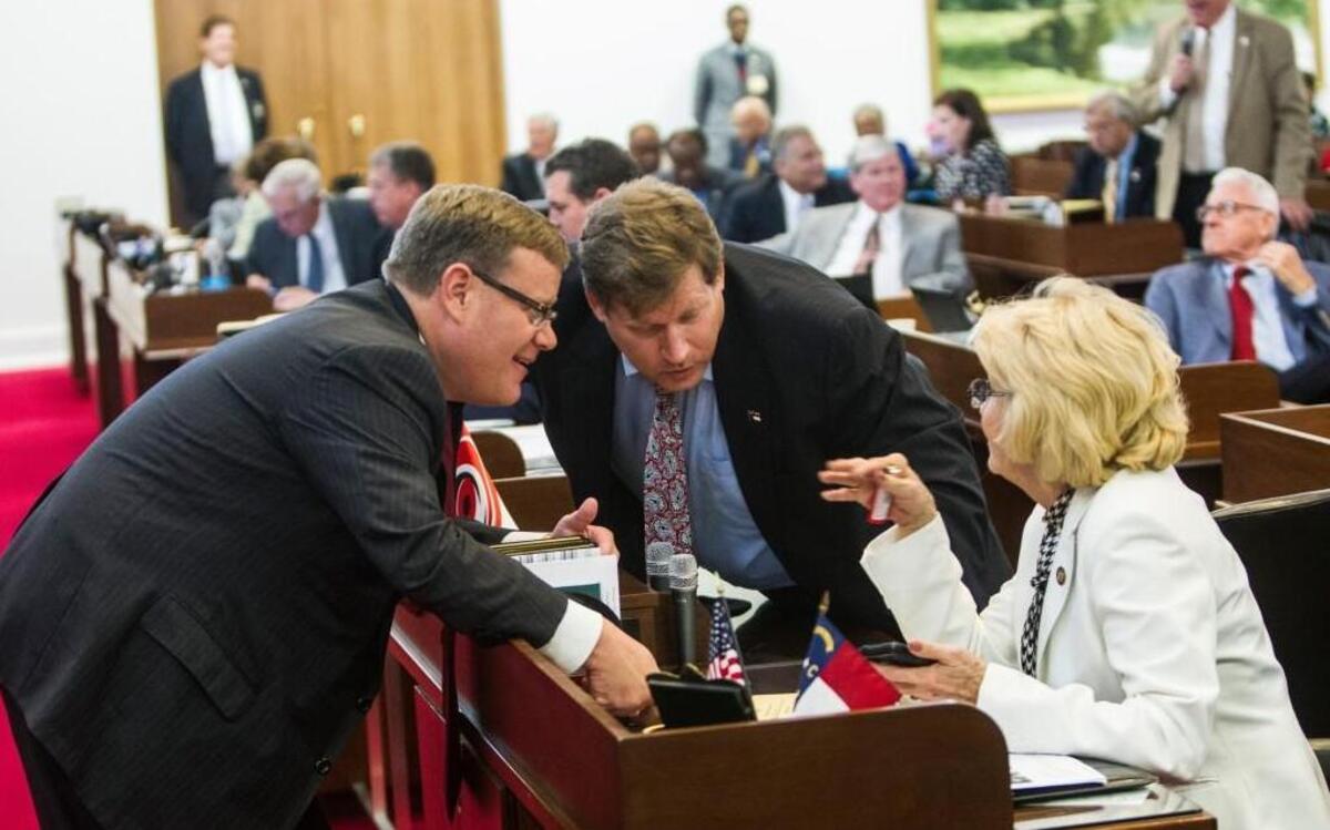 Speaker Tim Moore, left, talks with Reps. Nelson Dollar and Linda Johnson during a House session Wednesday, August 5, 2015 at the Legislature Building. State legislators are considering further changes to the tax policy.
