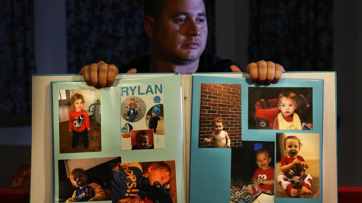 Corey Ott displays a book of photographs of his son, Rylan Ott, who drowned in a North Carolina pond while under the care of his mother, Samantha Bryant.