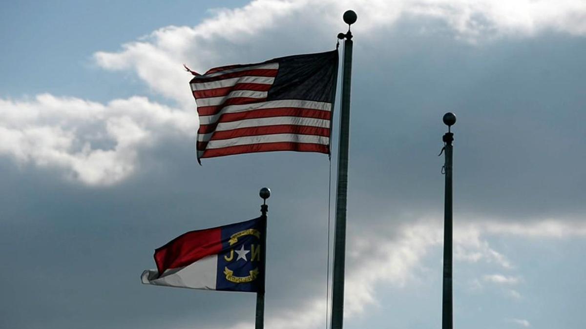 The U.S. flag and North Carolina flag flutter in the breeze.
