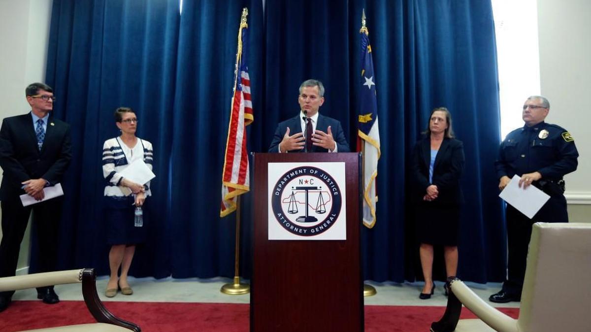 NC Attorney General Josh Stein, center, said he had to cut about 45 workers from his department due to budget cuts during a press conference held in his offices in Raleigh on Aug. 3, 2017. He is flanked by district attorneys and law enforcement agency representatives.