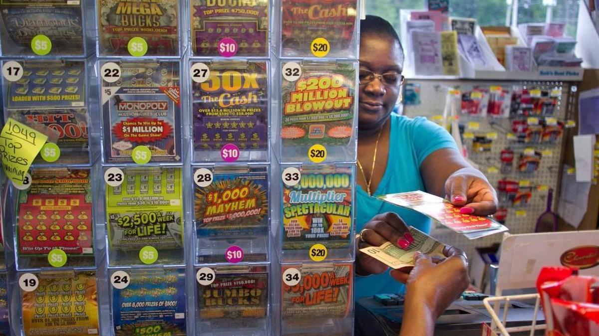 C-Mart employee Monique Benjamin sells scratch-off lottery tickets to a customer on Aug. 18, 2015 on Poole Road in Raleigh, N.C.