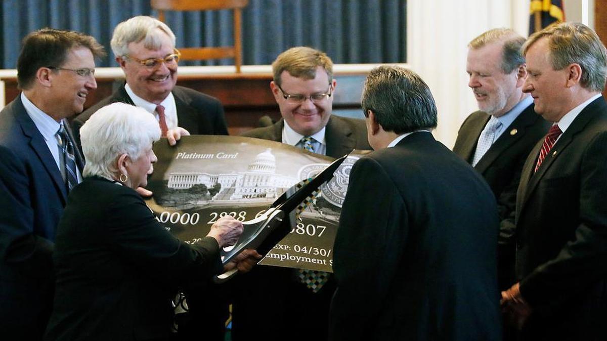 
In this 2015 file photo, from left, then-Gov. Pat McCrory, State Rep. Julia Howard, Commerce Secretary John Skvarla III, House Speaker Tim Moore, Sen. Bob Rucho, Senate President Pro Tempore Phil Berger and assistant commerce secretary Dale Folwell participate in a ceremonial cutting up of a federal government credit card in the old NC House chamber in the State Capitol. The state announced the complete repayment of its debt to the federal government for unemployment insurance.
