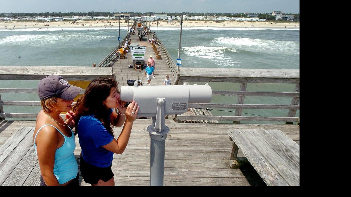 Vacationers use a telescope on the Bogue Inlet Pier to look for the rental house they are staying in at Emerald Isle.