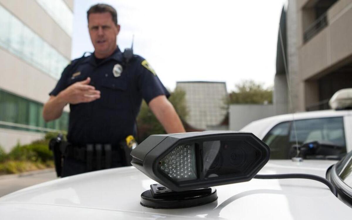 In this photo taken Aug. 30, 2011, patrol officer Chris Stout demonstrates a license plate recognition device that the Springfield Police Dept. is trying out during a news conference in Springfield, Ill.