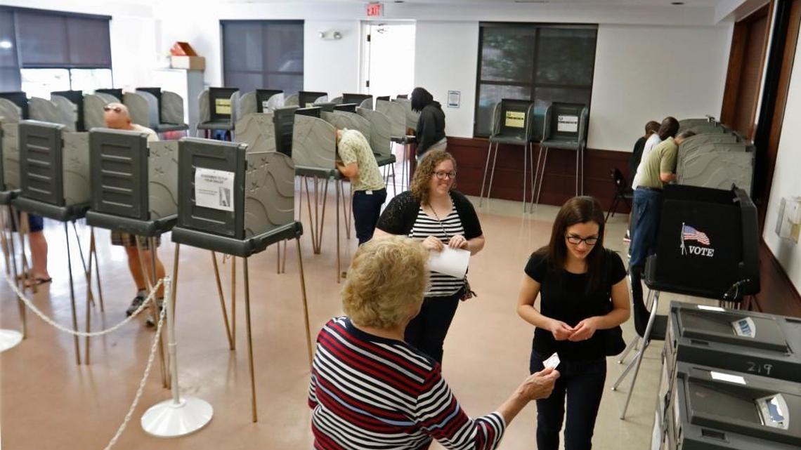 A Wake County voter is offered an “I Voted” sticker after putting her ballot into the vote tally machine at the Herbert C. Young Community Center early voting site in Cary, N.C., Friday, March 11, 2016.