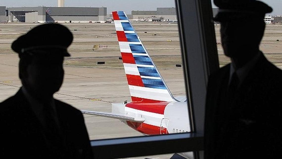 Pilots look out on an American Airlines Boeing 777-300 at DFW Airport on the day that American announced a merger with US Airways in 2013. (Star-Telegram/Ron T. Ennis)