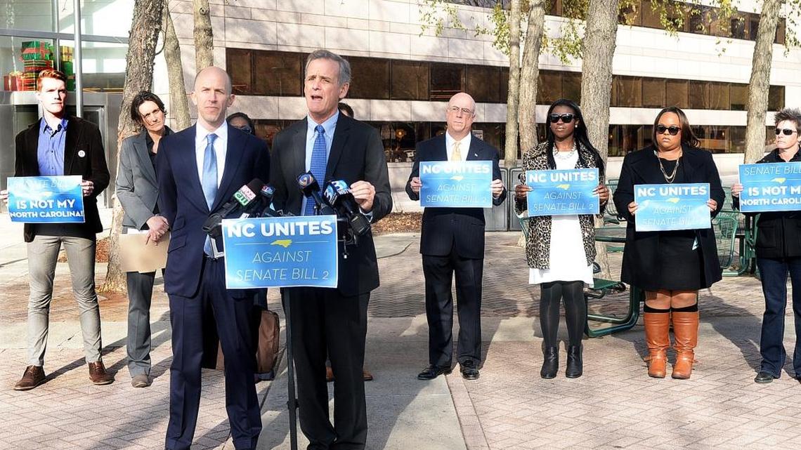 Charlotte attorneys Jake Sussman, left front, and Luke Largess speak at a December press conference announcing their legal challenge to the magistrates’ law