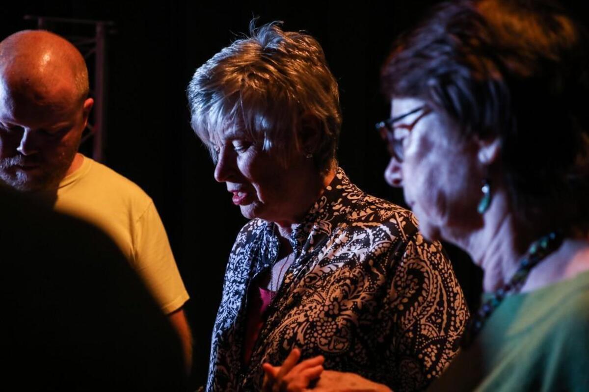 Debbie Moss, center, leads her church's band in prayer before service on Sunday Nov. 12, 2017.