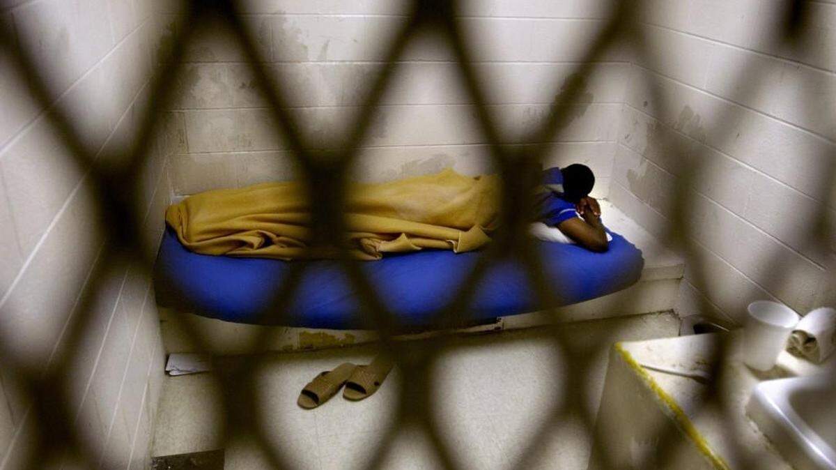 A juvenile sleeps on a bunk in a segregation unit at Dobbs Youth Development Center in Kinston on May 6, 2003.